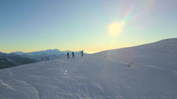 在阳光明媚的雪山坡上徒步向上。