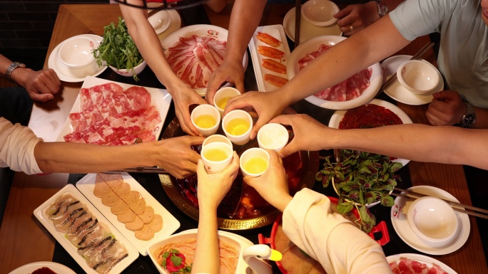 重庆麻辣涮火锅聚餐的人们举杯庆祝节日喝酒