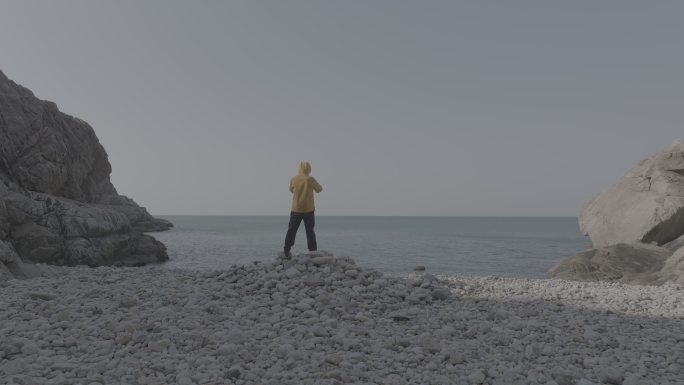 航拍威海靖子头鹅卵石海滩黄色冲锋衣飞手