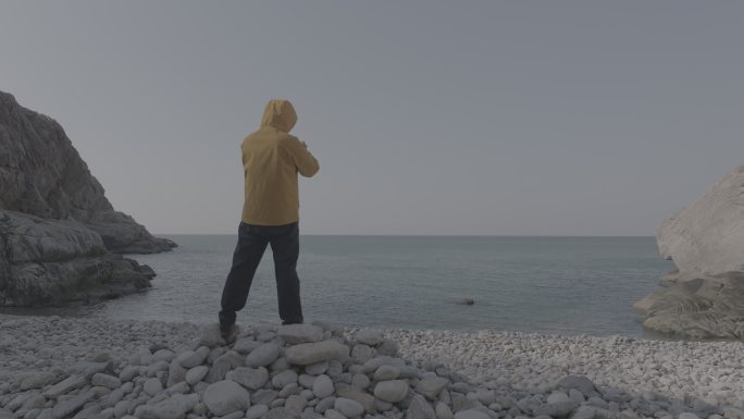 航拍威海靖子头鹅卵石海滩黄色冲锋衣飞手