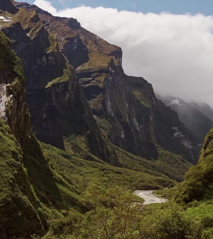 陡峭崎岖的山谷风景，喜马拉雅山脚下郁郁葱葱的山谷，底部有壮观的悬崖和河流，位于尼泊尔的喜马拉雅山脉景