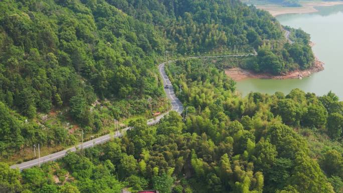 越野车行驶在弯曲的水库山路上新农村