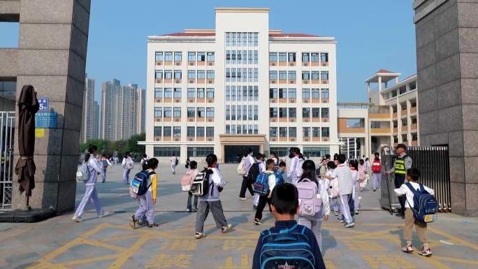小学生上学进校园以及教室里学生早读背诗文