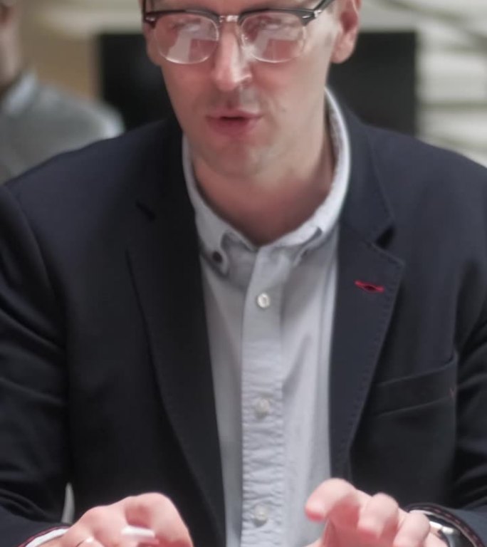 在创意办公室，富有成效的同事们站在桌子旁，进行公司会议。商务人士使用平板电脑讨论战略。团队合作与社交