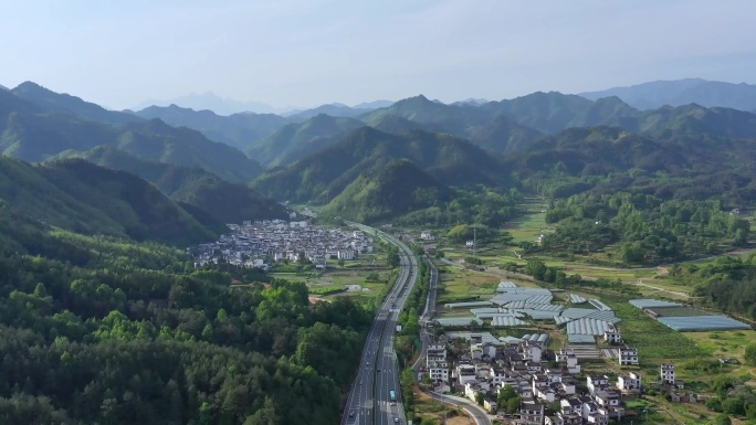 高速公路航拍穿过群山徽派村庄