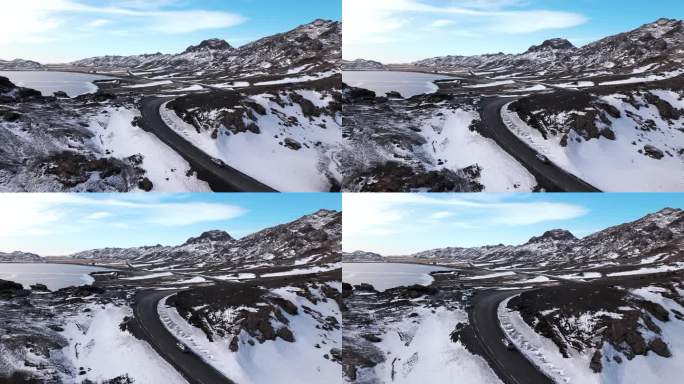 灰色轿车在冰岛雪山公路上行驶，空中推进镜头，白天。