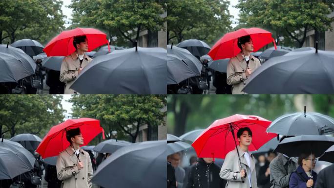 雨中人群持红伞男士