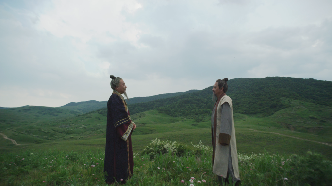 山野间的古装人物对话草地上的传统文化交流