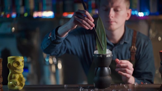 咖啡师调制异国鸡尾酒，使用柠檬酒和果汁。