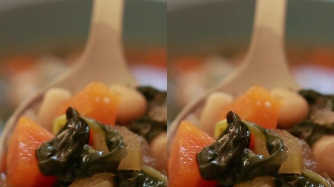 浓郁的意大利豆子菠菜汤在轻轻炖煮，顶部撒上新鲜磨碎的帕尔马干酪。