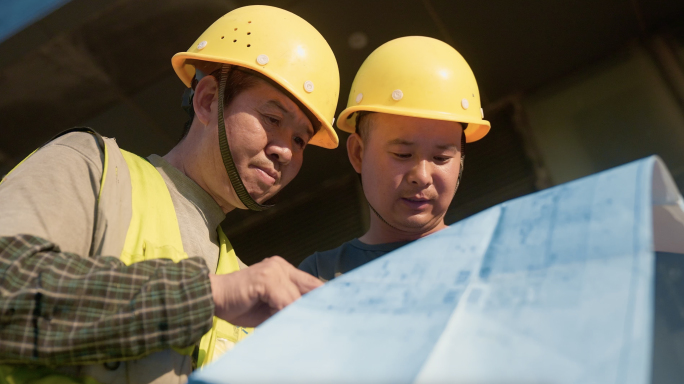 建筑工人在工地看施工图纸
