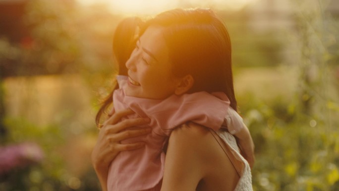母女在花园浇花的温馨时光亲子拥抱幸福生活