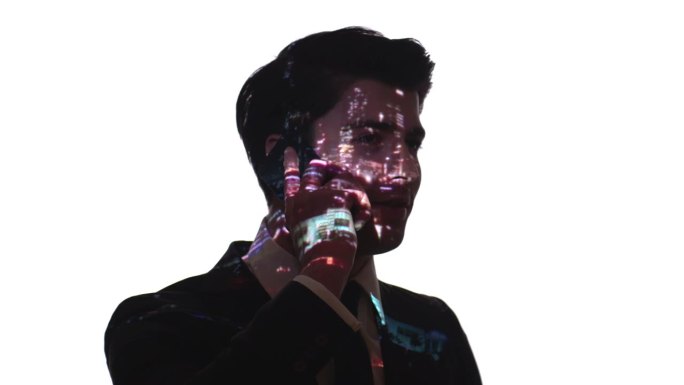 城市灯光投射在一个商人的脸上