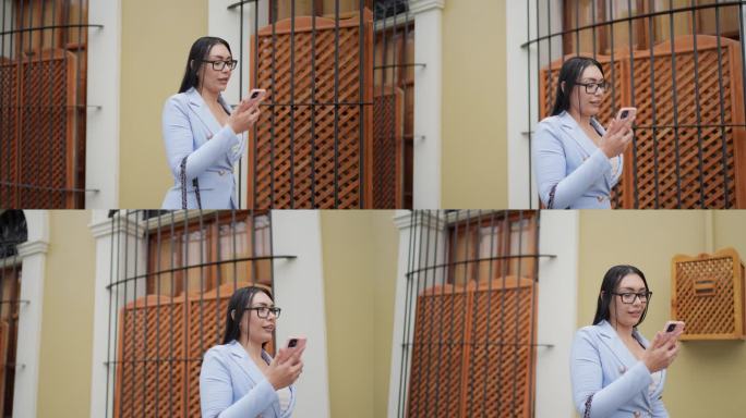 中年成年女商人在历史街区的户外用手机做视频通话