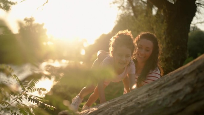 母亲正在帮助女儿爬树