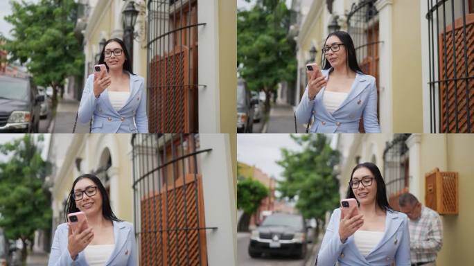 中年成年女商人在历史街区的户外用手机做视频通话