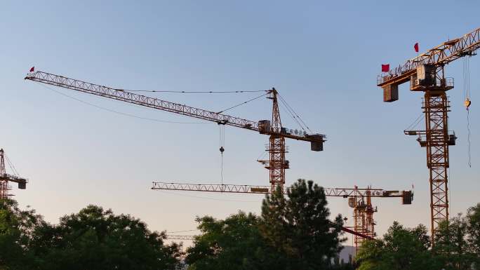 夕阳下城市建设中的塔吊群