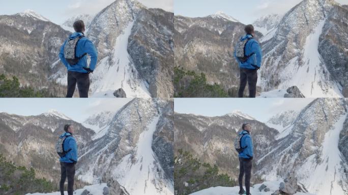 中年登山运动员从山顶俯瞰山谷
