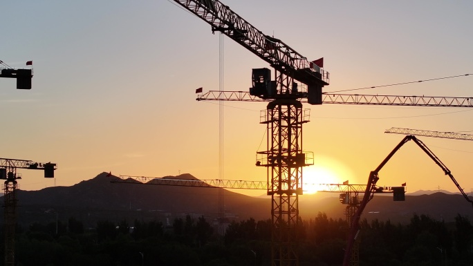 夕阳下的塔吊剪影山脉落日航拍