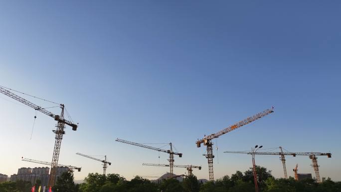 夕阳下城市建设塔吊林立
