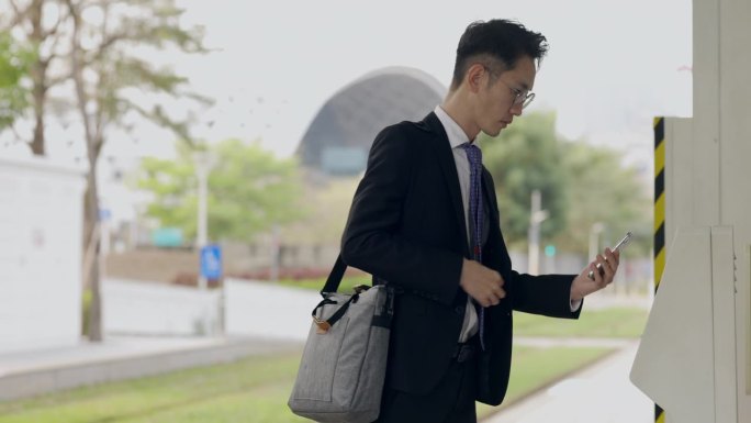 一名亚洲男性正在用手机里的数字钱包支付地铁票。