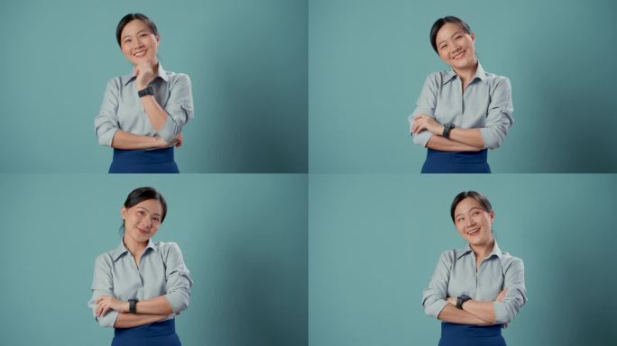 亚洲女人快乐自信地站在蓝色的背景隔离双臂。