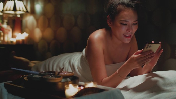 王女士裹着毛巾在床上放松后，温泉美容治疗