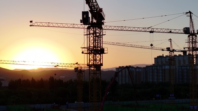 夕阳下的建筑工地剪影航拍塔吊