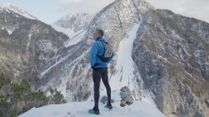 中年登山运动员从山顶俯瞰山谷