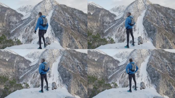 中年登山运动员从山顶俯瞰山谷