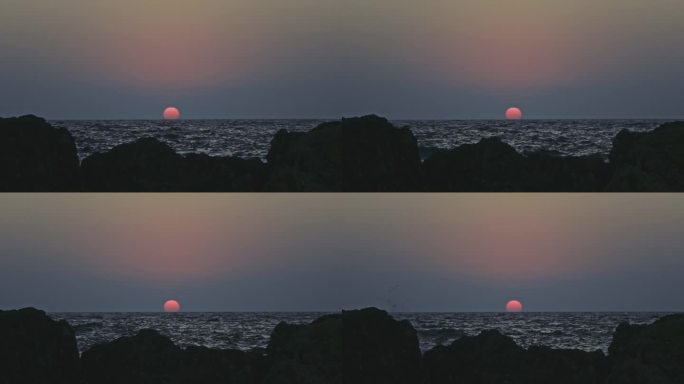 橙色的天空和日落在灰色的大海或海洋的平静波浪上。宁静、禅宗般的电影场景。慢动作视频。
