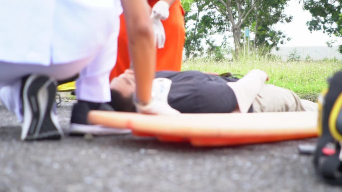 救护小组抢救一名车祸受害者的受伤人员