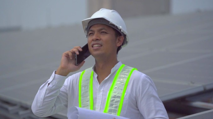 电气工程师在屋顶检查太阳能电池板的施工。