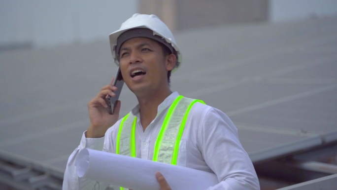 电气工程师在屋顶检查太阳能电池板的施工。