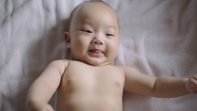 5个月大的男婴看着镜头，带着幸福的感觉微笑