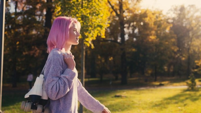 穿着轮滑鞋在城市公园散步的时尚年轻女子，积极的生活方式