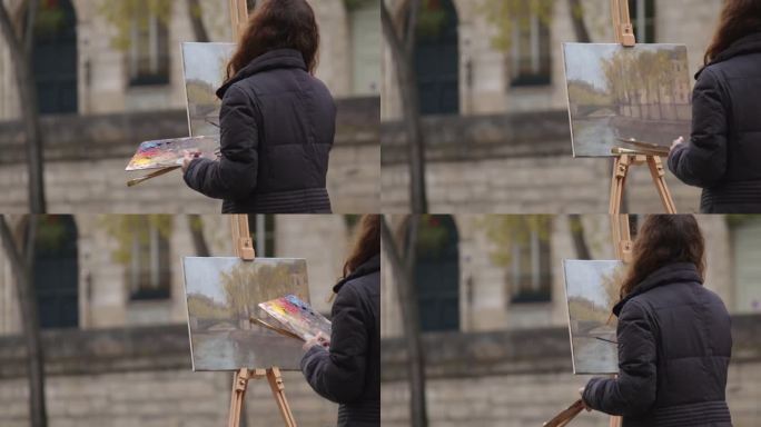 一个女人在塞纳河附近画画。一位富有创造力的女艺术家站在巴黎的画架旁，用画笔作画。女艺术家，艺术销售，