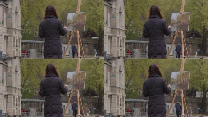 一个女人在塞纳河附近画画。一位富有创造力的女艺术家站在巴黎的画架旁，用画笔作画。女艺术家，艺术销售，