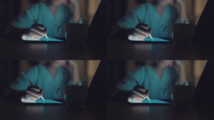 商务女性在家用笔记本电脑工作时，在数字平板电脑上使用触控笔