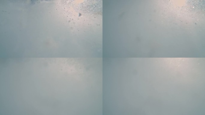 超级慢动作的时间扭曲飞溅的雪对天空。阳光明媚的日子里，雪山的景色。探索自然。