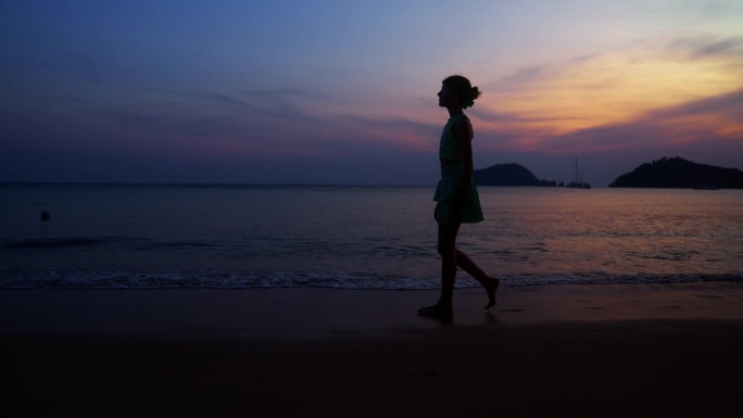 女孩在海边散步的侧视图