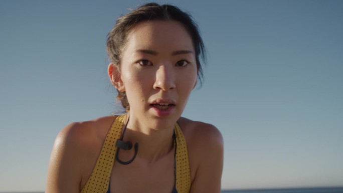 年轻的亚洲女跑步者休息，美丽的女运动员在激烈的跑步锻炼后疲惫不堪，享受健身生活方式的挑战，在日出的海