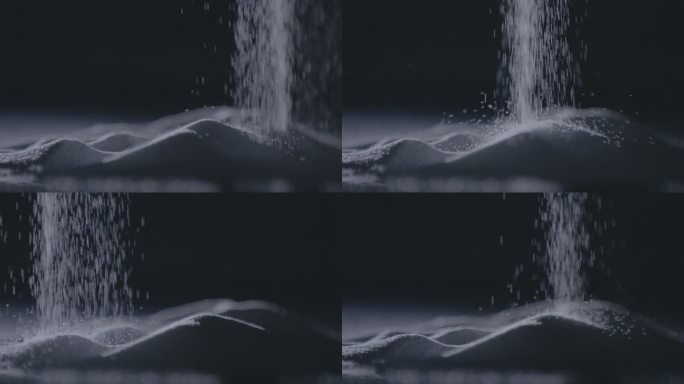一只手在戏剧性的灯光下轻轻按压细砂糖，画面以慢动作捕捉。