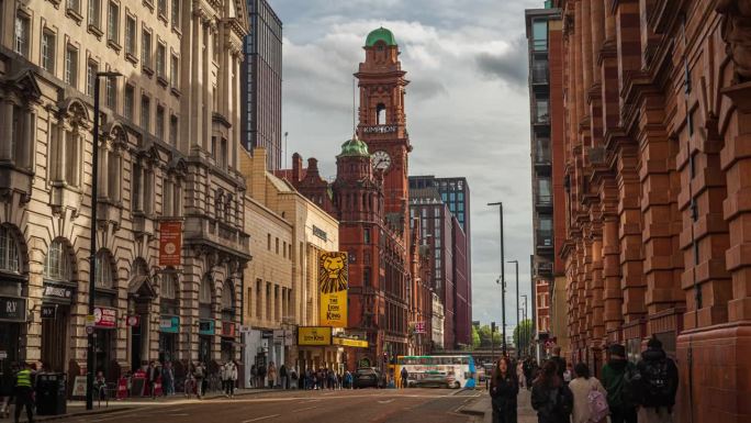 拥挤的通勤者和游客在曼彻斯特牛津路，金普顿钟楼周围行走和旅行的时间流逝