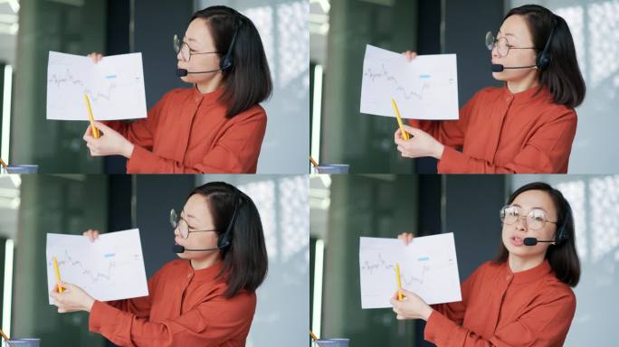 关闭了。摄像头的观点。图为，一名亚洲女性经理坐在办公室里用笔记本电脑进行视频会议。