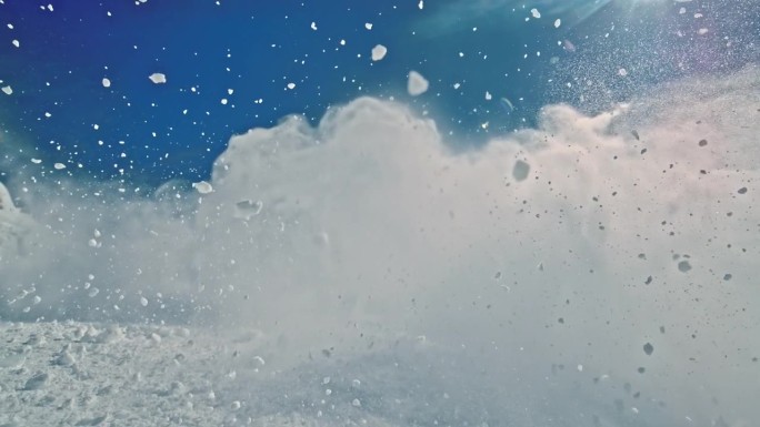 空中雪花飞溅的超级慢动作时空扭曲。雪山在阳光明媚的日子。探索自然。