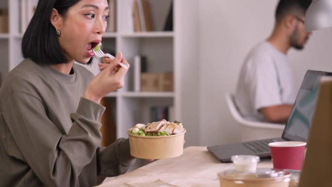 女性在工作时享用健康餐，女商人在办公室休息吃午餐。