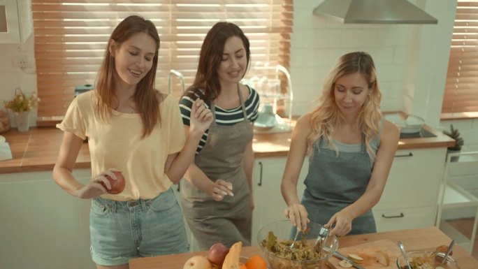 女团正在厨房里享受准备食物和跳舞的乐趣