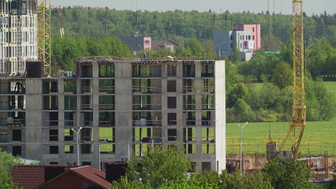 施工起重机用于新建多层住宅的施工。起重机在工作。新建多层住宅的延时施工与开发。房地产