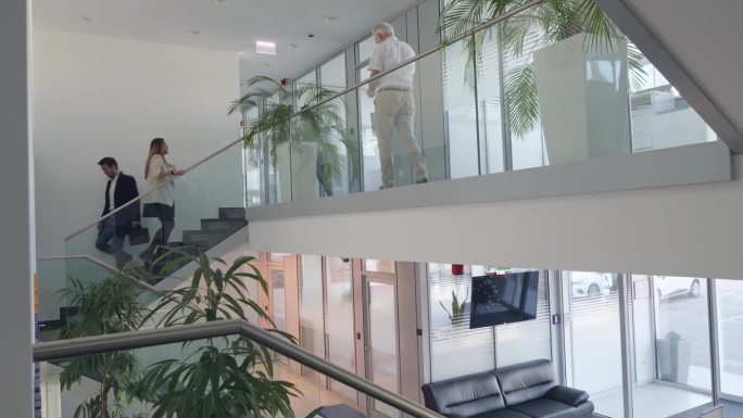 员工走在现代化的办公大厅和走廊里